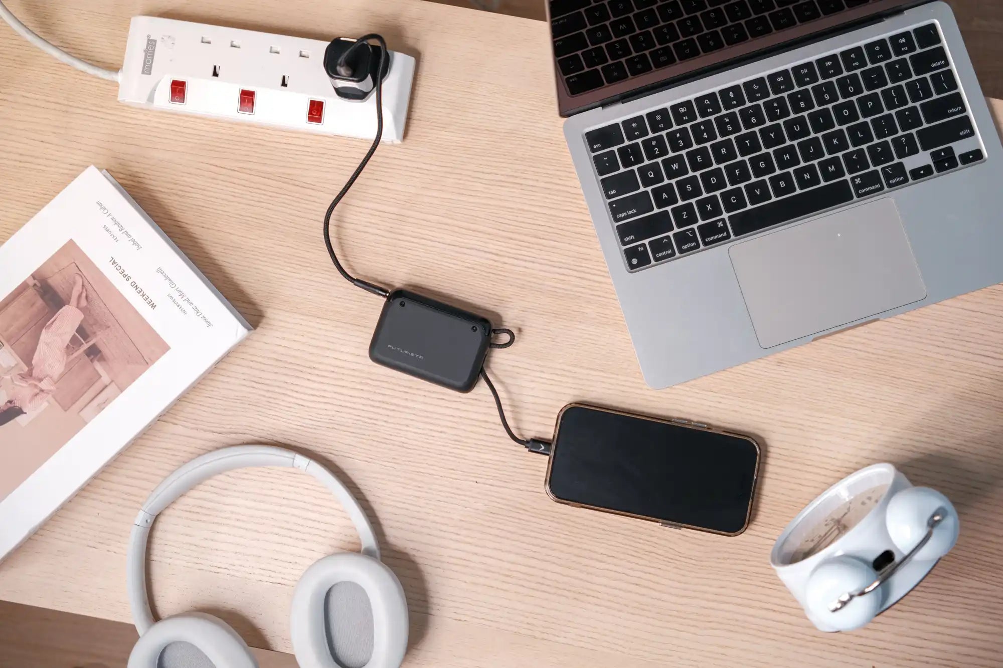 Black charging hub connected to a phone and power strip.