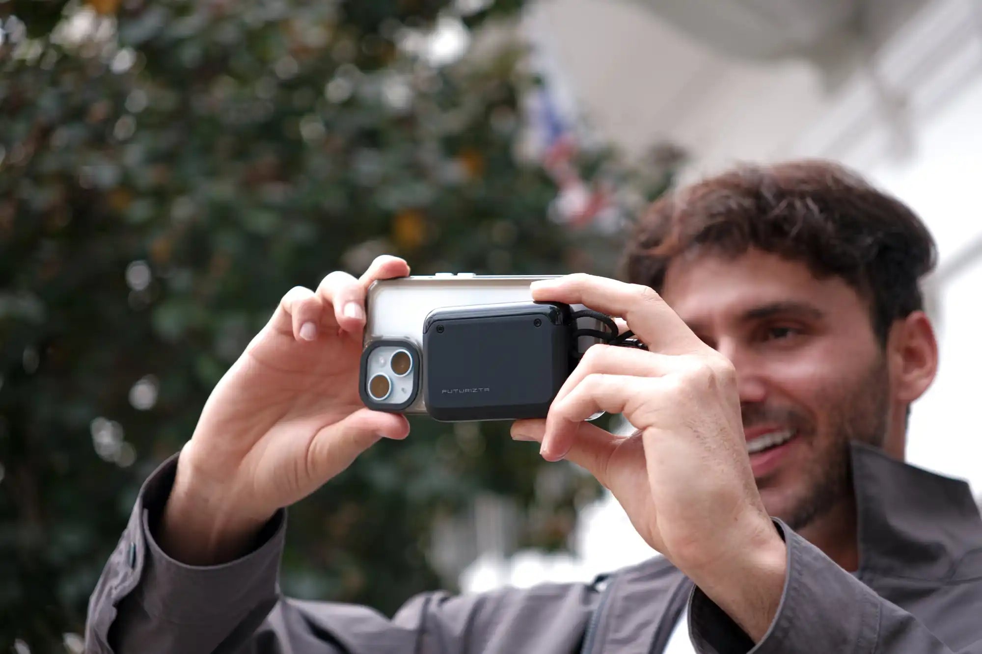 Man taking a photo with a smartphone and external flash.