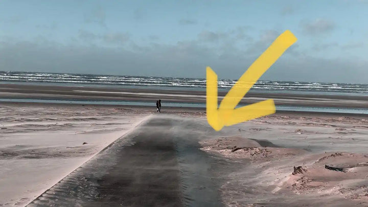 Sandy beach with water.