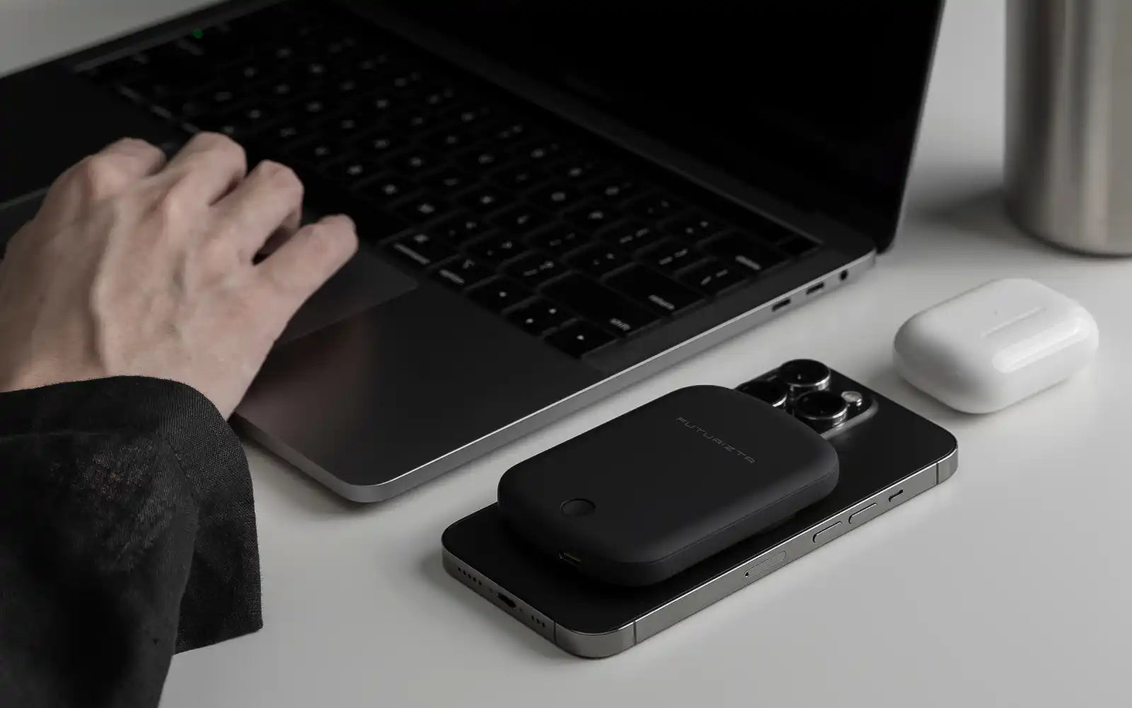 Black phone with a charging pack and white earbuds.