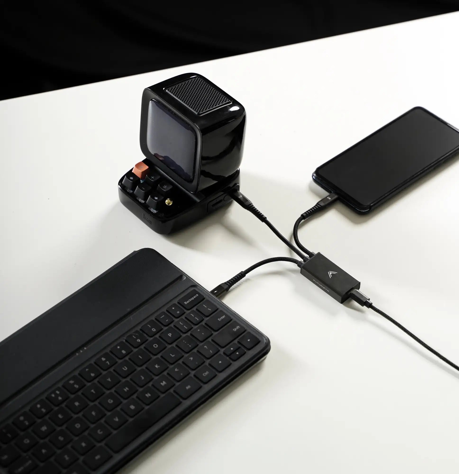 Black retro-style portable speaker with a small screen and keyboard-like controls